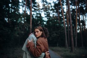 romantic couple in the forest in a coat, gloomy date sadness and peace.