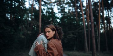 romantic couple in the forest in a coat, gloomy date sadness and peace.